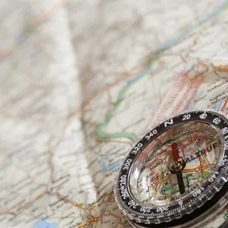 Ein Kompass wird zur Navigation auf einer Karte benutzt.