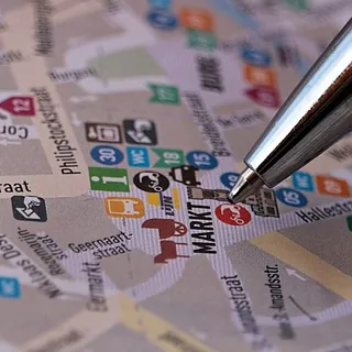 Ein Stift markiert eine Position auf einem Stadtplan.