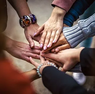 Hände, die Einheit und Gemeinschaft symbolisieren.